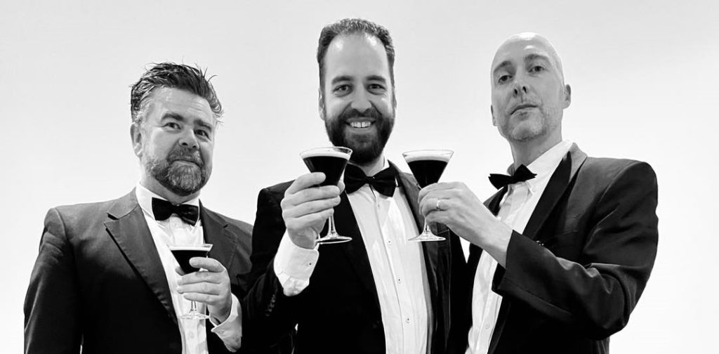 Men in black tie enjoy espresso martinis at a 1920s themed event