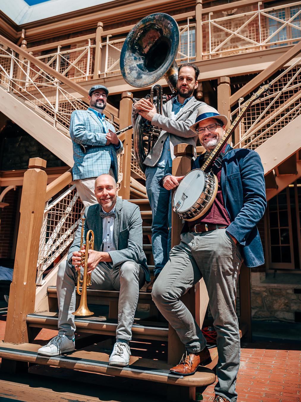 ASB in dapper attire on steps with instruments.