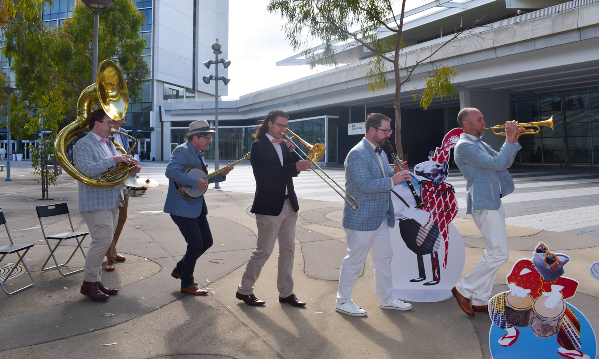 Atlantic Street Band dressed in summer wedding vibes to pose with instruments in front of Adelaide Airport